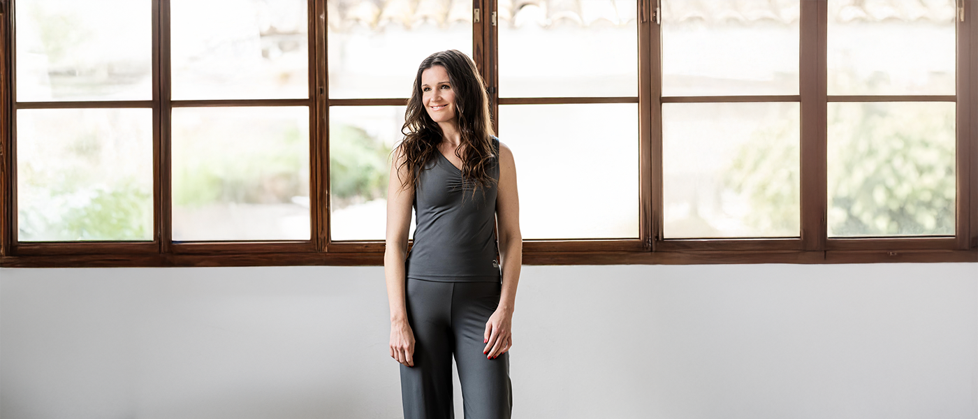 Confident woman wearing a high-waisted wide-leg pant and fitted tank top from Theia Moon, designed to empower women every day