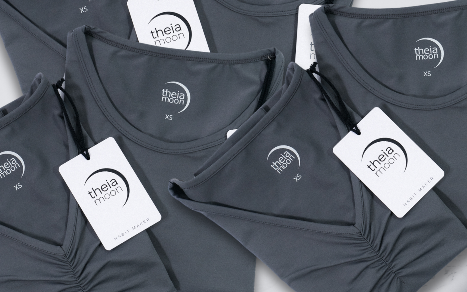 Flat lay image of Theia Moon's two activewear tops: a tank top and a 3/4 sleeve t-shirt, made from recycled fibers and designed for an active lifestyle